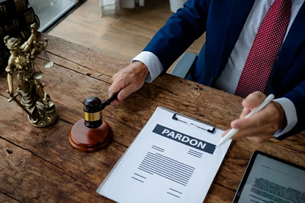 Patrol officers team arresting male offender on city street. Policewoman reporting to police station by radio while policeman putting handcuffs on hands of violator